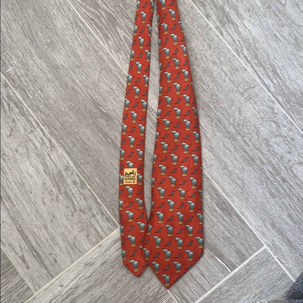 Reddish orange Hermès tie with mouse and elephant